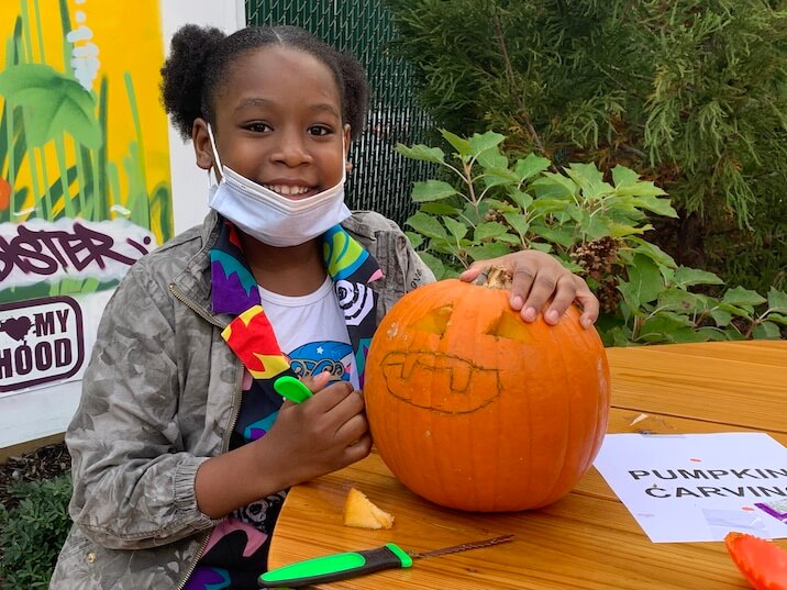 child decorating pumpkin
