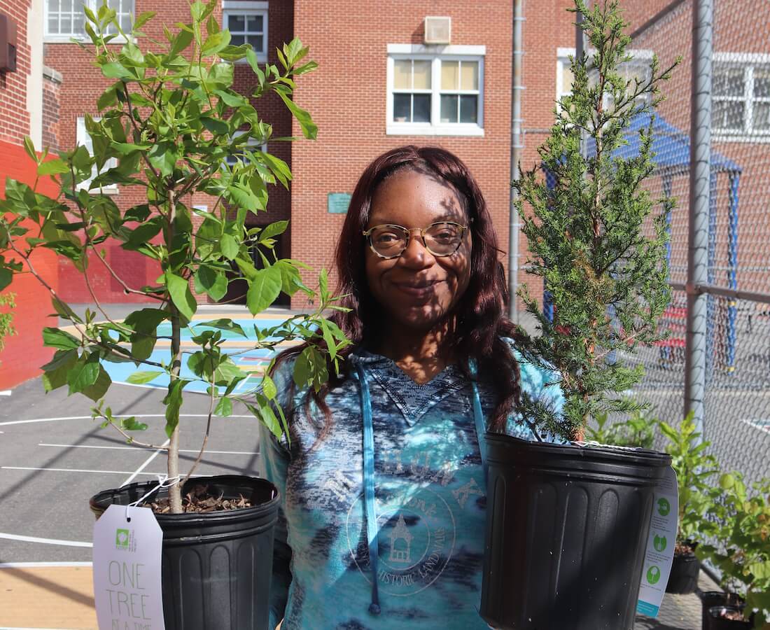 girl holding two trees