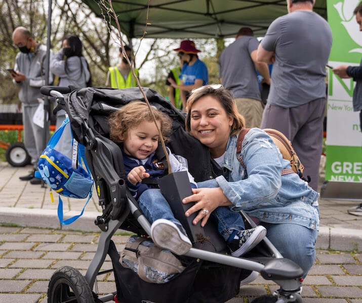 adult and child smiling with tree