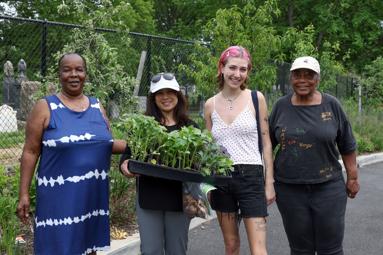 people standing and smiling with plants in garden