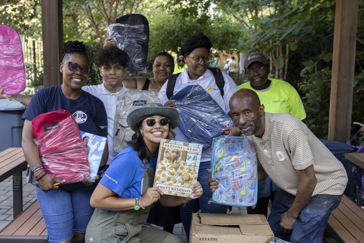 people holding backpacks and books