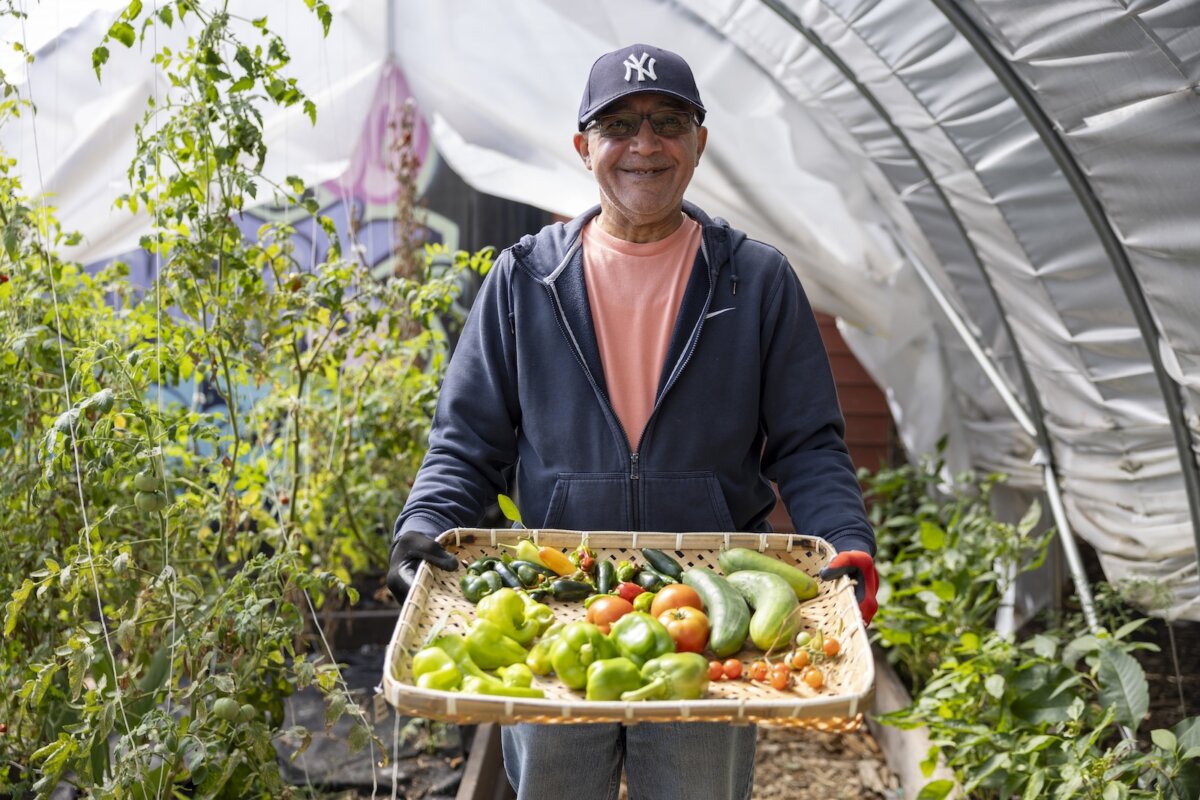 person smiling holding vegetables