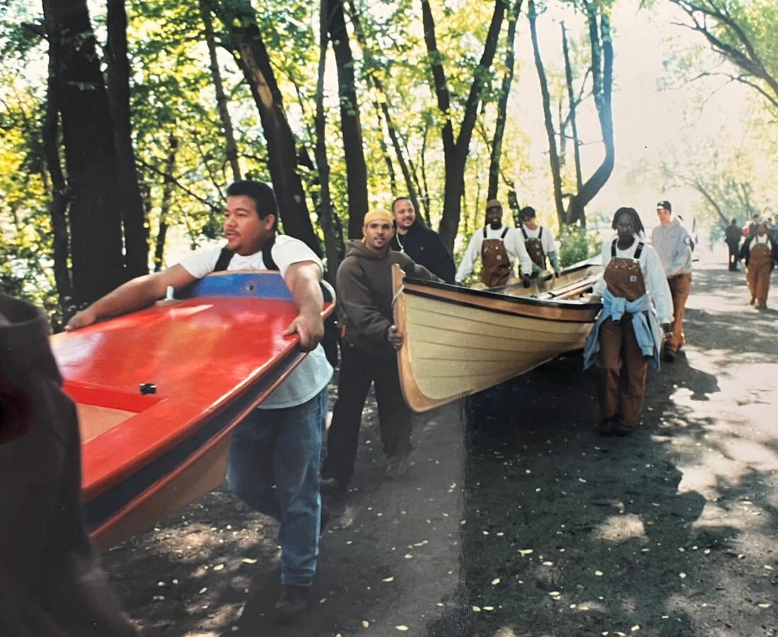 people carry boats along waterfront