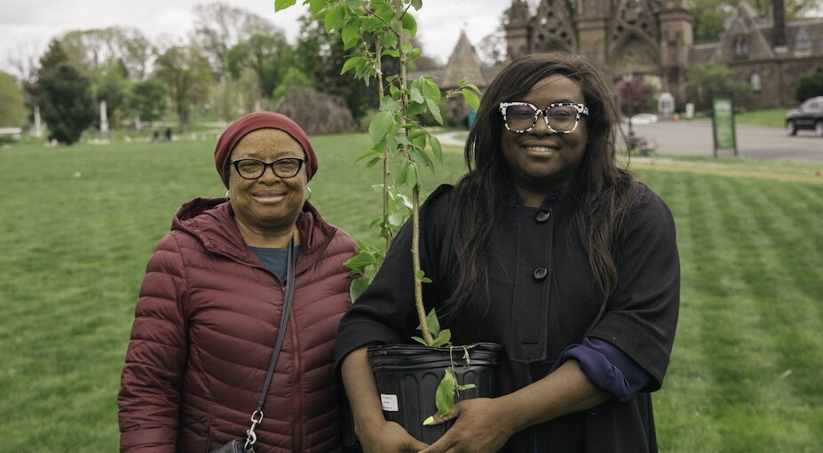 people holding a potted tree
